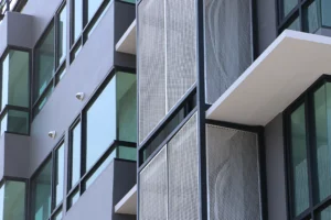 Perforated mesh panels add texture, ventilation, and shading to sleek urban architecture