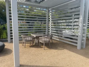 Open-air cabana provides shaded dining space with contemporary woven seating