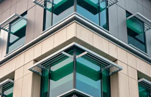 Teal glass windows framed by vertical and horizontal metal fins on modern building corner